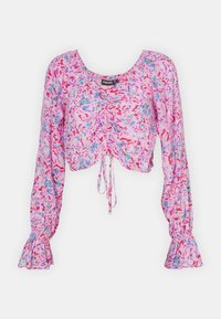 Rosa, kort bluse med lange klokkesømsærmer, som har et blomsterdesign i rød, blå og lilla. Rynket front og snøredetalje.