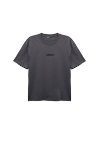 Graues Baumwoll-T-Shirt mit Rundhalsausschnitt. Verfügt über kurze Ärmel und trägt das Wort "BRÜSSEL" in dunkler Schrift auf der Vorderseite.