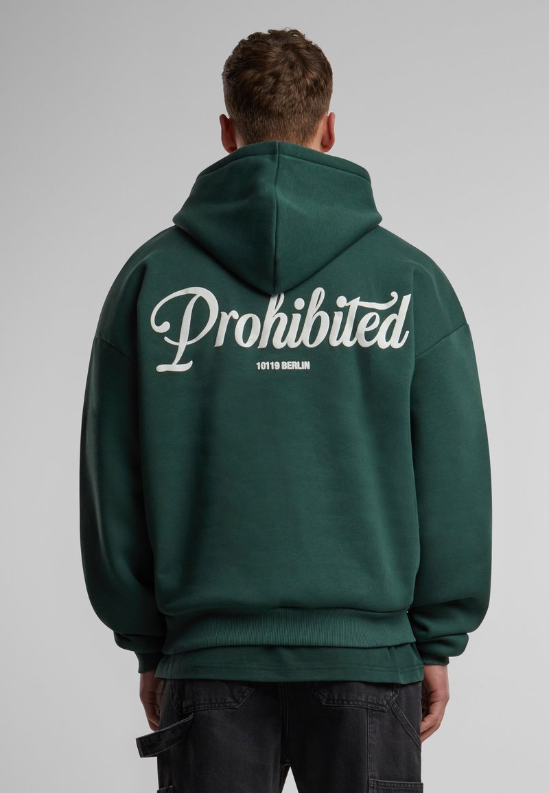 Sudadera con capucha de tejido verde oscuro. Presenta un gran texto blanco "Prohibido" en la parte posterior, con "10119 Berlín" debajo en tamaño más pequeño. Puños y dobladillo acanalados.
