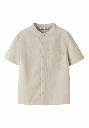 Camicia beige a maniche corte con colletto alla coreana, dotata di chiusura con bottoni sul davanti e taschino sul petto. Realizzata in tessuto leggero con una consistenza liscia.