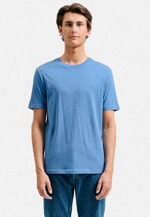 Blå crew neck t-shirt lavet af blødt, let stof. Korte ærmer med en afslappet pasform. Bæres med blå denim jeans.