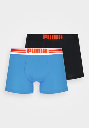 Twee paar boxershorts; één blauw met een witte en rode tailleband, één zwart met een rode tailleband. Glad, elastisch materiaal.