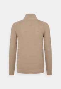 Maglione beige a maglia con collo alto, caratterizzato da un motivo testurizzato e polsini a costine. Progettato per una vestibilità comoda e maniche lunghe.