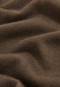 Brauner Strickstoff mit glatter Textur, der ein dezentes Rippmuster und eine weiche, leicht strukturierte Oberfläche aufweist.