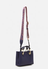 Borsa a tracolla in pelle blu navy con dettagli in oro, manici superiori e una tracolla rimovibile con motivo rosso e blu che presenta del testo.