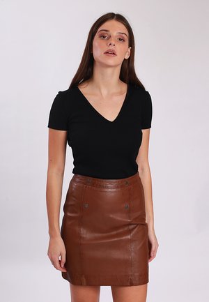 Czarny prążkowany top z krótkim rękawem w połączeniu z brąskową skórzaną mini spódnicą z przednimi guzikami i gładką teksturą.