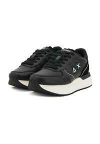Zwarte lage sneakers met dikke witte zolen, zwarte veters, geometrische witte symbolen op de zijkanten en het "SUN68" logo op de tong.