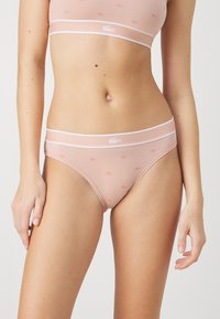Light pink cotton lingerie set featuring a seamless design. The bra and panties have white trim and a small Lacoste logo pattern.