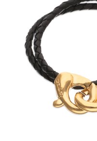 Cordón trenzado de cuero negro con un cierre metálico dorado diseñado en forma de corazón, con textura suave y acabado pulido.