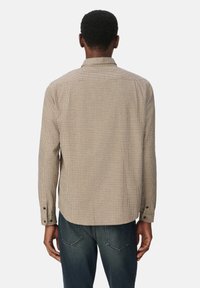 Bruine en beige geruite overhemd met lange mouwen, een kraag, knoopmanchetten en een rechte houtrand. Gemaakt van een lichtgewicht stof.