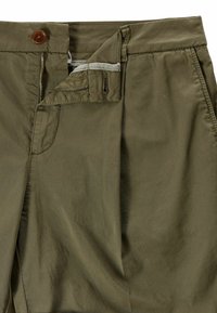 Pantaloni verde oliva con zip parzialmente aperta, chiusura a bottone marrone e tasche laterali, che mostrano la trama del tessuto e i dettagli delle cuciture.