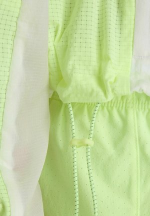 Hellgrüner Netzstoff mit kleinen Perforationen, weißes, durchscheinendes Stoffpaneel und verstellbare Kordeln mit Kunststoffklemmverschluss.