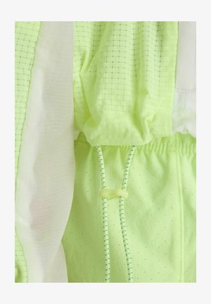 Lichtgroene gaasstof met kleine perforaties, wit doorschijnend stofpaneel en verstelbare trekkoorden met plastic schuifknop.