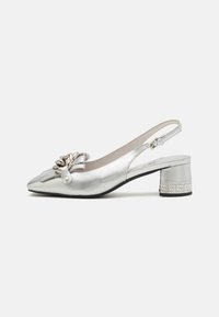 Hopeapintainen slingback-kengä, jossa on terävä kärki, rusettiyksityiskohta ja matala paljettikorko, jossa on koristeellinen strassiraita. Sileä metallinen pinta.