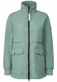 Chaqueta verde claro con cuello alto, cierre frontal de cremallera y dos grandes bolsillos. Cuenta con puños elásticos y una textura suave y mate.