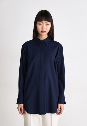 Camicetta blu navy a maniche lunghe con colletto a punta, chiusura a bottoni e taglio dritto, realizzata in tessuto morbido e leggero.
