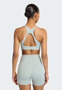 Lichtblauwe sportbeha en bijpassende hoge shorts, met een uitgesneden ontwerp op de rug en een soepele, rekbare stof.