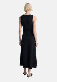 Schwarzes ärmelloses Kleid mit figurbetontem Oberteil und ausgestellt Rock. Hergestellt aus strukturiertem Stoff, verfügt es über einen mittigen Reißverschluss auf der Rückseite und einen knielangen Saum.