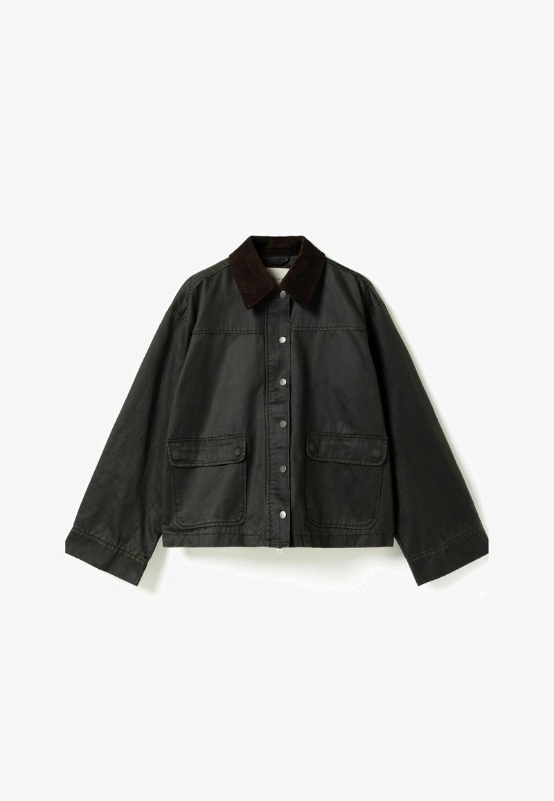 Veste vert foncé longueur hanches avec col en velours côtelé noir, boutons-pression sur le devant et deux grandes poches à rabat sur la poitrine.