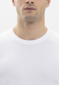 White cotton t-shirt with a round neckline and short sleeves, featuring a smooth texture and a fitted design that highlights the upper body.