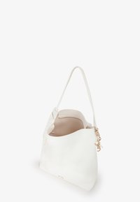 Witte leren tote bag met een ronde vorm, enkele schouderband en een gladde textuur. Heeft een gouden hardwareaccent aan de zijkant.