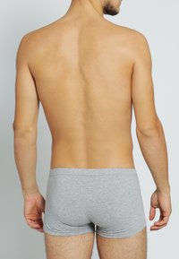 Grau Baumwoll-Boxershorts mit weicher Textur, enganliegendem Design und elastischem Bund, von hinten an einem männlichen Modell gezeigt.