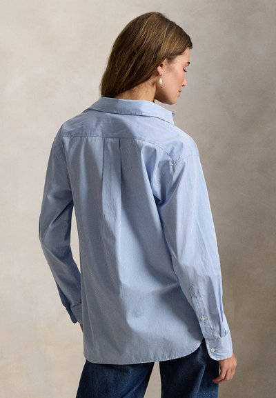 Ανοιχτογαλανή ριγωτή πουκαμίσα με κουμπιά, κλασικό γιακά, μακριά μανίκια και άνετη γραμμή, κατασκευασμένη από μαλακό ύφασμα. Διαθέτει πλαϊνό ένθετο στην πλάτη και πιέτες.