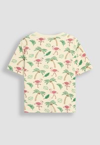 Lühikeste varrukatega heledat kollast särk, millel on roosa flamingo, roheliste palmipuude ja roheliste lehtede muster pehmel puuvillakattel.