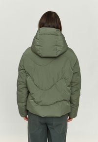 Olive green puffer jacket with a hood, featuring quilted texture and curved seam patterns. Back view shows elastic cuffs and hem.