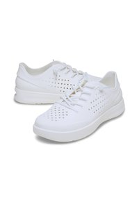 Scarpe da ginnastica bianche realizzate in materiale impermeabile e liscio, con un design perforato per la traspirabilità e suole in gomma piatta. I lacci garantiscono una vestibilità sicura.