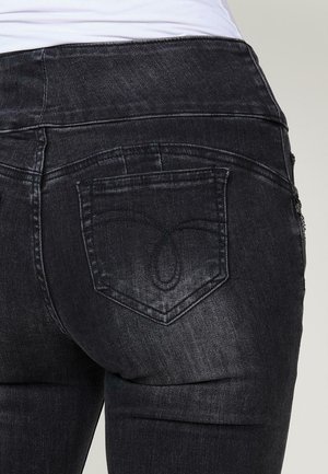 Dunkelblaue Jeans mit einem mittelhohen Bund, Gesäßtaschen mit gesticktem Detail und einer glatten, leicht abgetragenen Textur.