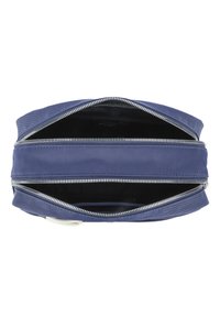 Marinblå tygväska med två blixtlås på toppen, har en smidig textur och ett rymligt inre, etikett synlig inuti.