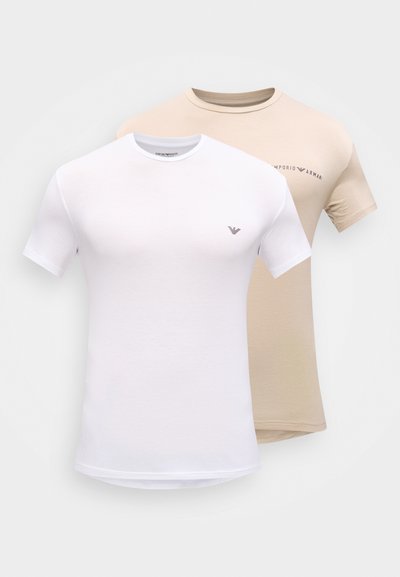 Δύο απλά κοντομάνικα μπλουζάκια με στρογγυλή λαιμόκοψη για άνδρες, ένα λευκό με μικρό λογότυπο στο στήθος και ένα μπεζ με το όνομα της μάρκας στο στήθος.