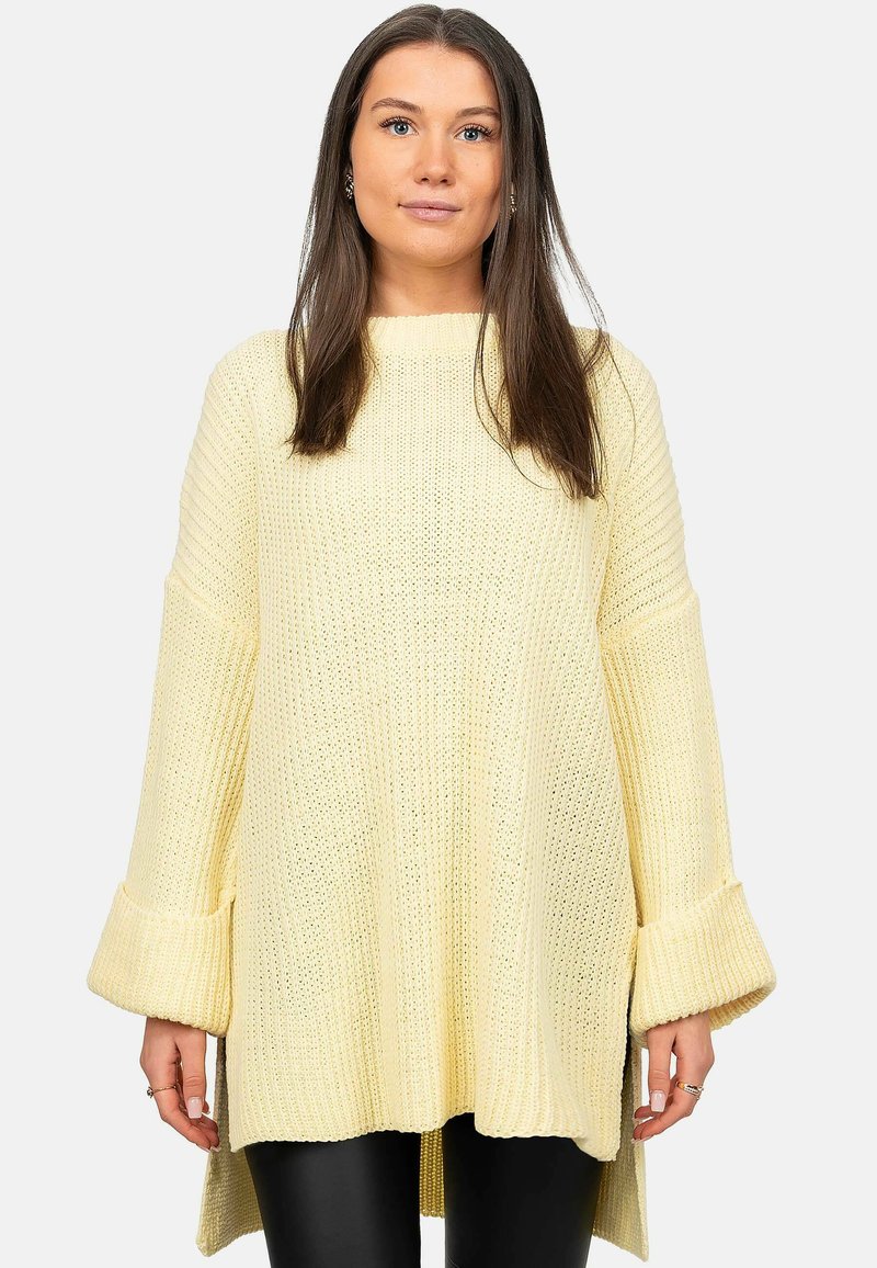 Maglione lavorato a maglia di un giallo chiaro con una vestibilità ampia, maniche larghe e orlo asimmetrico. Presenta un motivo testurizzato e polsini a coste.