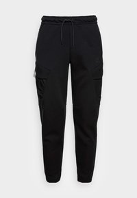 Black tapered sweatpants with elastic waistband, drawstring, and zippered side cargo pockets, made from mixed fabric panels.