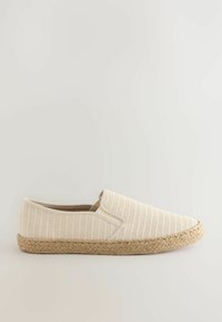 Beige slip-on sko med tekstureret stofoverdel og vævet jutesål. Har en rund tå og ingen synlige lukninger. Glat inderside.