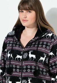 Felpa nera con zip e cappuccio, decorata con un motivo di renne e fiocchi di neve, dotata di un cappuccio nero, dettagli in rosa e bianco, e pompon decorativi.