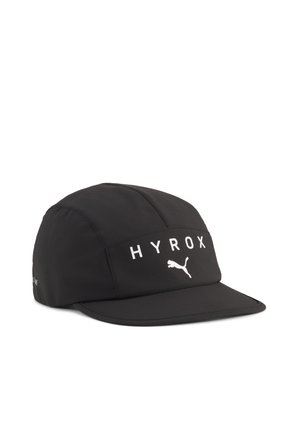 Czarna sportowa czapka z płaskim daszkiem, z białym napisem "HYROX" i logo Puma na przednim panelu, pokazana na białym tle.