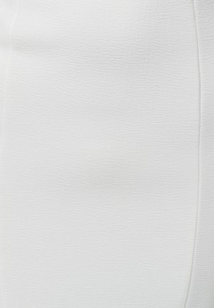 Texture in pelle bianca con grana sottile e dettaglio di cucitura lungo il bordo destro.