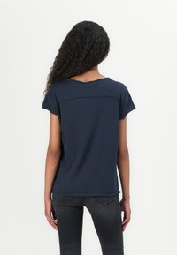T-shirt à manches courtes bleu marine en tissu doux, avec un col rond et une coupe décontractée, dotée de coutures au dos.