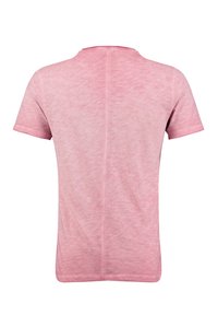 Camiseta de manga corta en una tela de color rosa claro jaspeado, con escote de barco y un corte holgado con un dobladillo recto.