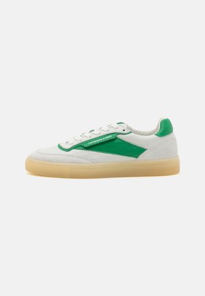 White sneaker with green leather accents, beige sole, and white laces, showing the side with "Copenhagen Studios" text on the green detail.