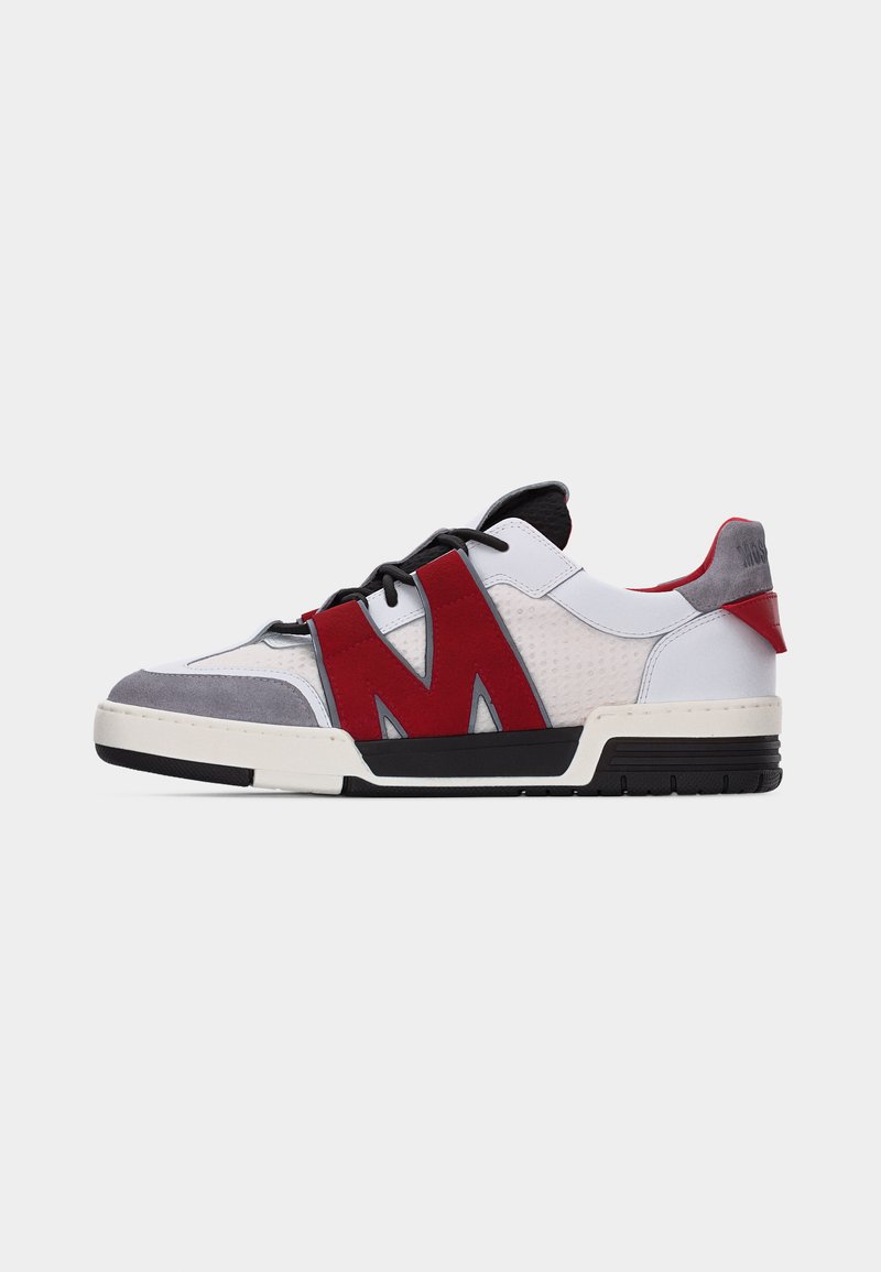 Χαμηλού τύπου αθλητικό παπούτσι με λευκό δέρμα, γκρι σουέντ μύτη, κόκκινες λουρίδες που σχηματίζουν το γράμμα "M", μαύρα κορδόνια και μαύρη-λευκή σόλα.