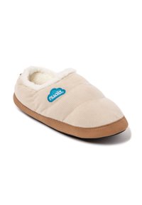 Zapatilla de terciopelo beige con forro de piel sintética, diseño acolchado y suela de goma marrón. Acento de logo azul en el costado.