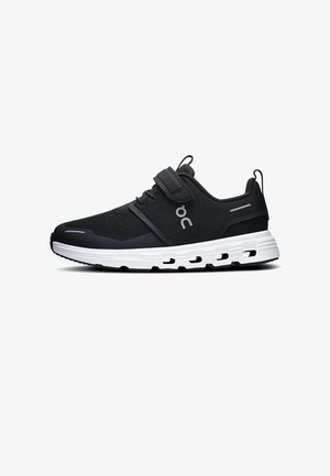 Chaussure de sport noire avec semelle blanche rembourrée, tige en mesh, sangle Velcro, languettes de traction et logo de la marque sur le côté.
