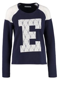 Felpa a maniche lunghe blu navy con dettagli in pizzo bianco sulle spalle e un grande design in pizzo "E" sul davanti. Tessuto morbido e casual.