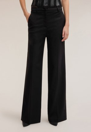 Zwarte wijde broek met een op maat gemaakte pasvorm, gladde textuur, voorzakken en een tailleband. Gecombineerd met een patroon tanktop.