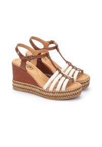 Sandalias de cuña de cuero marrón con diseño de tiras blancas, media suela de yute trenzado y correa ajustable en el tobillo. Plantilla acolchada para mayor comodidad.