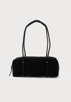 Juoda stačiakampė zomšinė rankinė su dviem ilgais plonais petnešomis ir užtrauktuko uždarymu ant paprasto šviesaus fono.