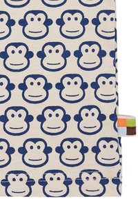 Baumwollstoff mit wiederholten blauen Affengesichtern auf einem cremefarbenen Hintergrund, mit einem bunten Stoffetikett an der Seite.